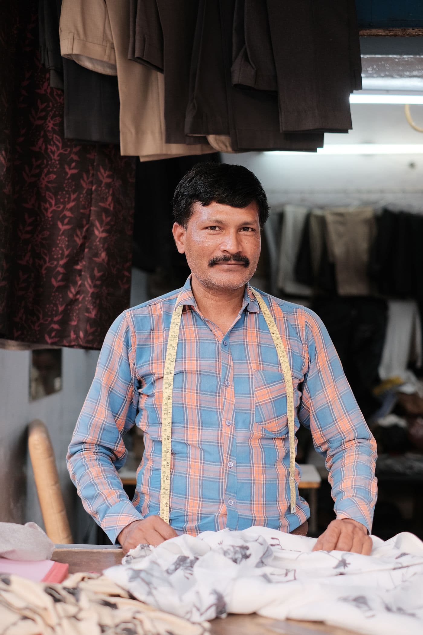 A tailor standing in the workshop he built up